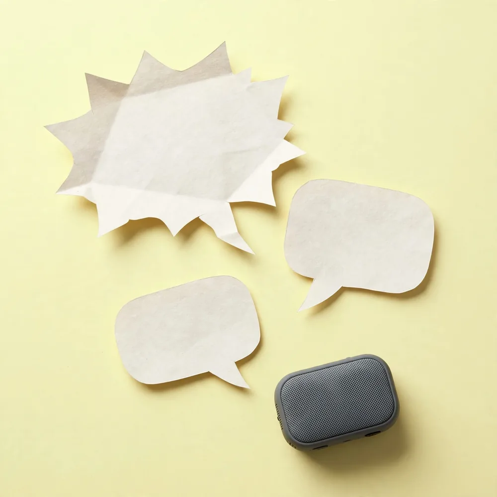 Paper speech bubbles and a speaker